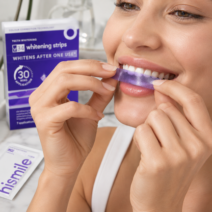 Woman applying teeth whitening strips with a box of VISA whitening strips in the background.