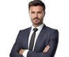 Man in a suit standing with arms crossed on a white background